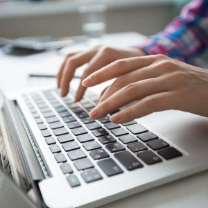 Cropped view of person hands typing on laptop computer